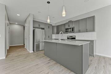 Edmonton apartment for rent - A modern kitchen with a large island and stainless steel appliances.