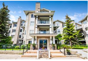 Calgary house for rent - A large, modern apartment building with a front entrance and a small garden area.
