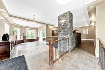 Calgary house for rent - A large open living room with a stone pillar and a balcony.