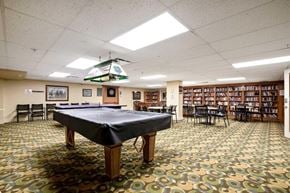 Calgary house for rent - A billiard table in a library with a pool table cover.