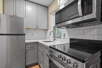 Denver apartment for rent - A kitchen with a stove, refrigerator, and microwave.