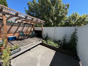 Vancouver apartment for rent - A backyard with a wooden deck and a white fence.