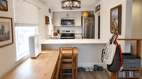 Vancouver apartment for rent - A kitchen with a wooden table and chairs, a refrigerator, a microwave, a stove, and a dishwasher.