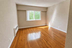Vancouver apartment for rent - A room with a window and wooden floors.