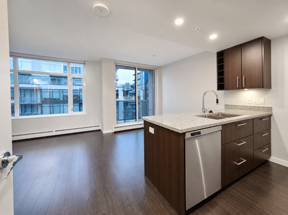 Vancouver apartment for rent - A kitchen with a sink, dishwasher and wooden floors.