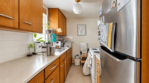 Vancouver apartment for rent - A kitchen with a refrigerator, sink, and cabinets.