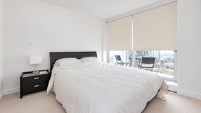 Vanvcouver apartment for rent - A bedroom with a large bed and a chair by the window.
