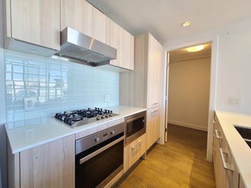 Vancouver apartment for rent - A kitchen with a stove top oven and a range hood.