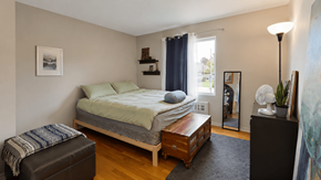 Vancouver apartment for rent - A bedroom with a bed, nightstand, and a chair.
