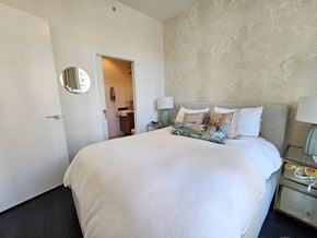 Vancouver apartment for rent - A bedroom with a large bed and a mirror on the wall.
