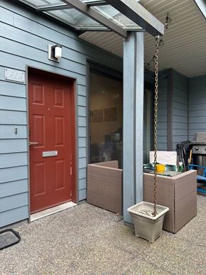 Vancouver apartment for rent - A red door is on the left side of a blue building.