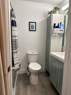 Vancouver apartment for rent - A small bathroom with a toilet, a sink, and a picture on the wall.