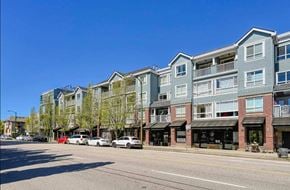 Vancouver apartment for rent - A row of apartment buildings line a street with cars parked on the side.