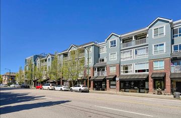 Vancouver apartment for rent - A row of apartment buildings line a street with cars parked on the side.