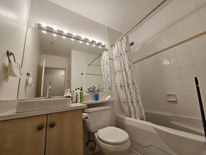 Vancouver apartment for rent - A bathroom with a white toilet, sink, and bathtub.