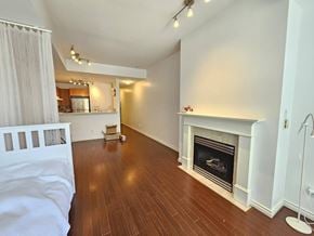 Vancouver apartment for rent - A white bedroom with a fireplace and wooden floors.