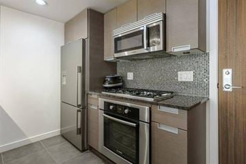 Vancouver apartment for rent - A modern kitchen with stainless steel appliances and a tiled backsplash.