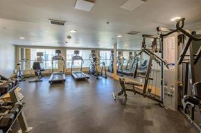 Vancouver apartment for rent - A spacious gym with various exercise equipment and mirrors.