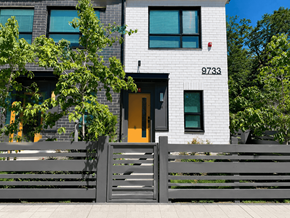 Burnaby apartment for rent - A modern house with a grey fence and a yellow door.