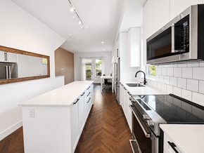Burnaby apartment for rent - A modern kitchen with white cabinets and black appliances.