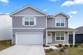 Lithopolis house for rent - A grey house with a white garage door and a small front yard.