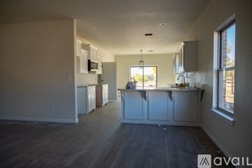 Claremore house for rent - A kitchen with white cabinets and a wooden floor.