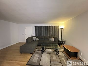 Hemet apartment for rent - A living room with a grey couch and a glass coffee table.
