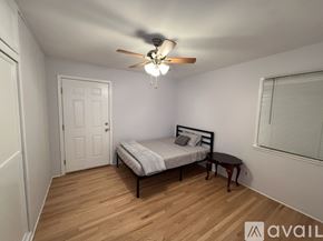 Hemet apartment for rent - A bedroom with a bed, a ceiling fan, and a small table.