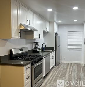 Hemet apartment for rent - A kitchen with white cabinets and a black stove top.