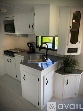 Key West apartment for rent - A kitchen with white cabinets and a black stove top.