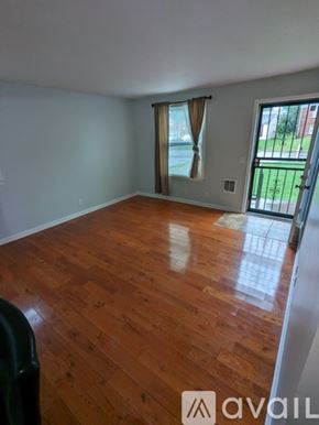 Nashville house for rent - A room with wooden flooring and a sliding glass door leading to a backyard.