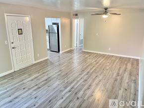 Phoenix apartment for rent - A spacious room with wooden flooring and a ceiling fan.