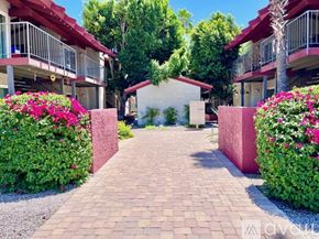 Phoenix apartment for rent - A red building with a balcony and a tree in front of it.