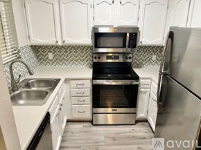 Phoenix apartment for rent - A kitchen with white cabinets and a checkered backsplash.