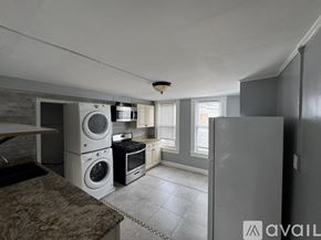 Baltimore apartment for rent - A kitchen with a washing machine and dryer stacked on top of each other.