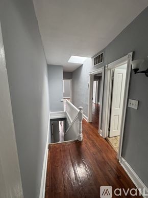 Baltimore apartment for rent - A hallway with a wooden floor and white walls.