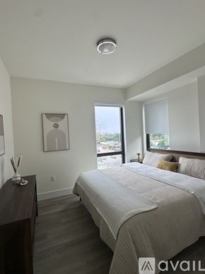 Oakland Park apartment for rent - A bedroom with a large bed and a window overlooking the city.