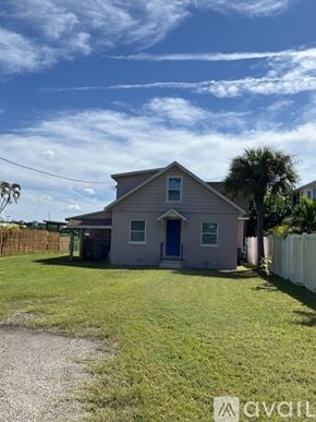 Tarpon Springs house for rent - A house with a blue door is surrounded by a white fence.