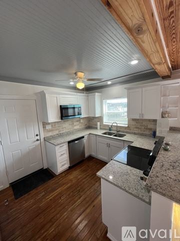 Tarpon Springs house for rent - A kitchen with a wooden ceiling and a granite countertop.