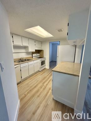 Port Charlotte apartment for rent - A kitchen with white cabinets and a wooden floor.