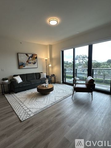 Oakland Park apartment for rent - A living room with a black couch, a coffee table, and a painting on the wall.