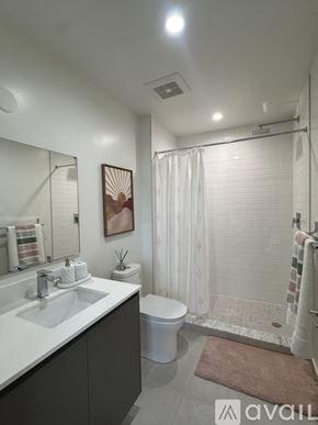 Oakland Park apartment for rent - A bathroom with a white sink, toilet, and shower curtain.