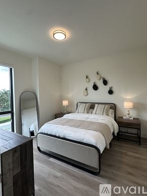 Oakland Park apartment for rent - A bedroom with a large bed and a wooden nightstand.