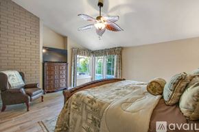 Huntington Beach house for rent - A bedroom with a large bed and a ceiling fan.