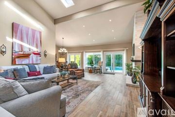 Huntington Beach house for rent - A spacious living room with a grey sofa and a chandelier.