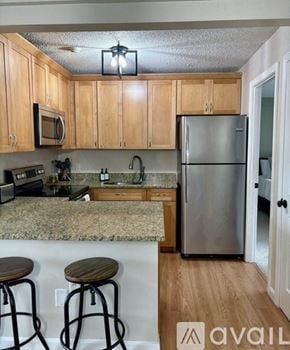 Laconia condo for rent - A kitchen with wooden cabinets and a granite countertop.