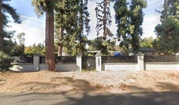 Los Angeles apartment for rent - A tree stands in front of a white fence.