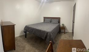Bullhead City apartment for rent - A bedroom with a bed, nightstand, and a wooden cabinet.