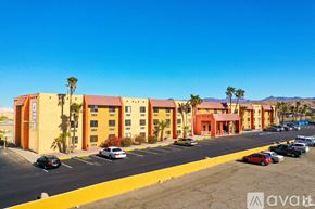 Bullhead City apartment for rent - A parking lot in front of a building with palm trees.
