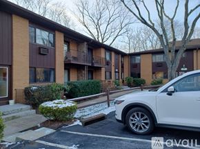 Piermont apartment for rent - A white car is parked in a parking lot in front of a building.